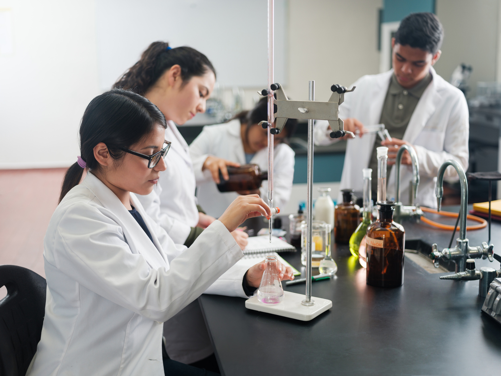 Lab students using laboratory flasks for research